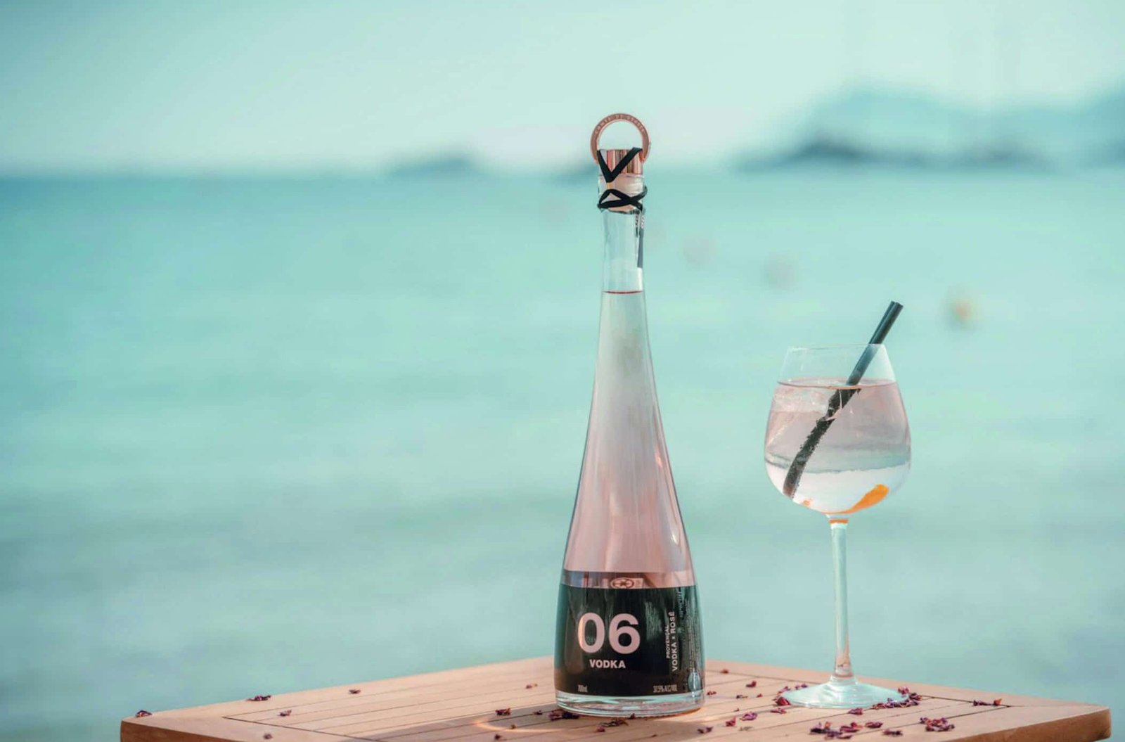 On a table by the ocean, a bottle of rosé is set for tasting, with accompanying notes.