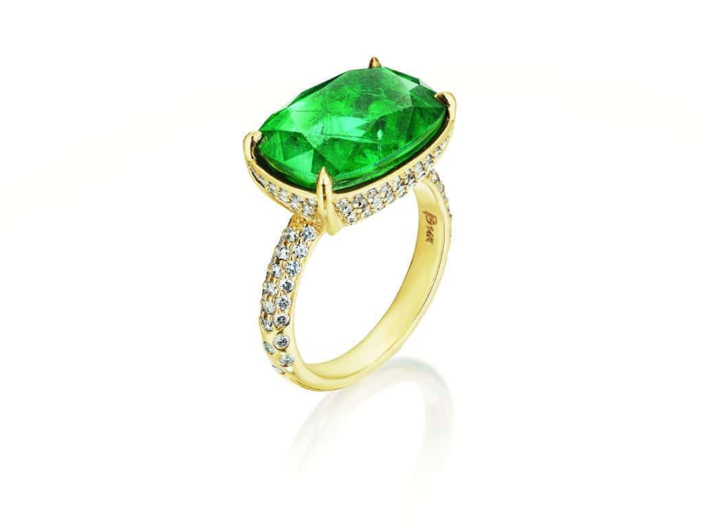 A classic yellow gold ring with a twist of an emerald stone and diamonds.