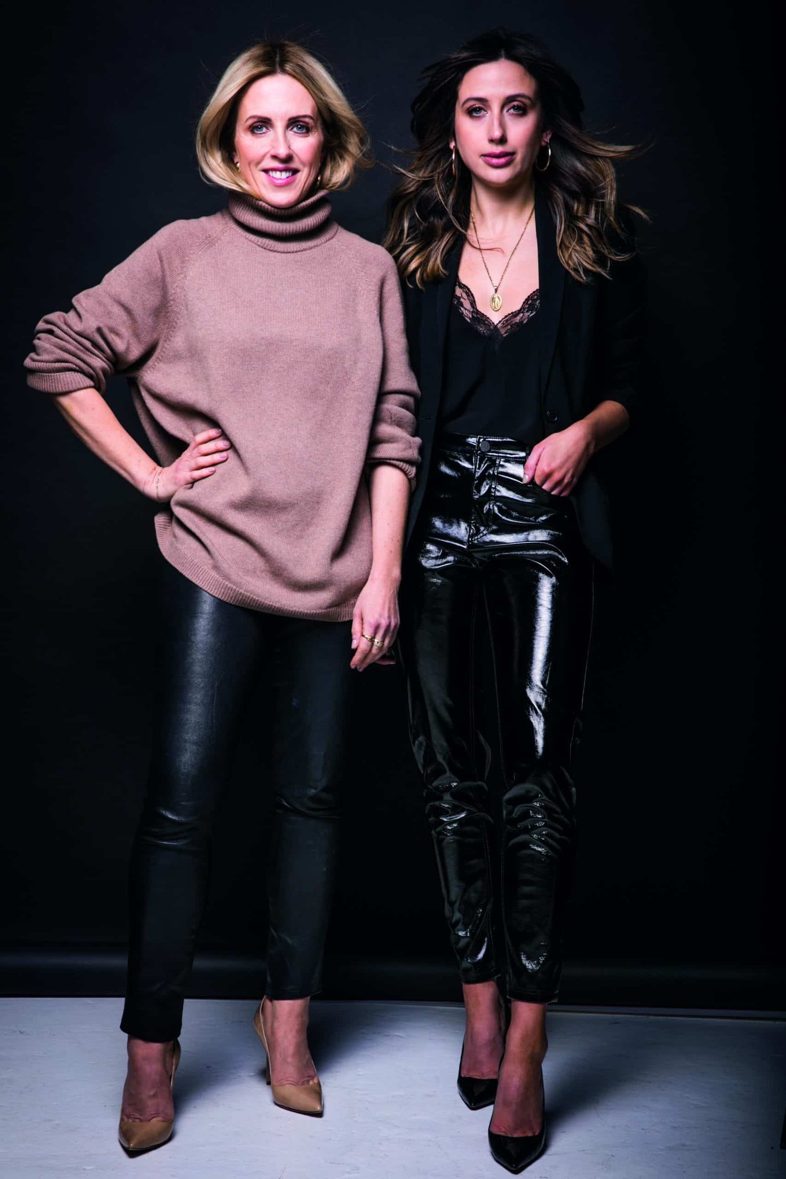 Two women in leather pants fulfilling a photo pose.