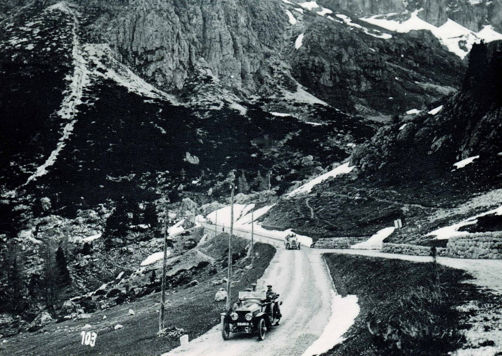 A man driving a car down a mountain road as part of an adventurous trial.