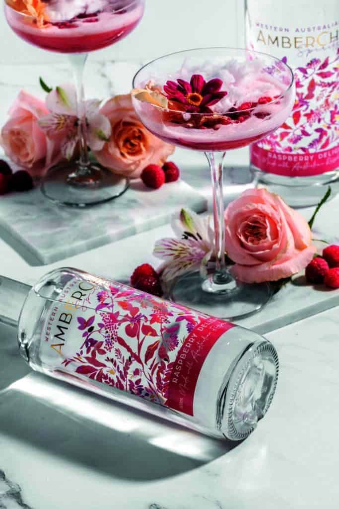 A bottle of gin and a glass of roses on a marble table, hinting at a secretive affair within the family.