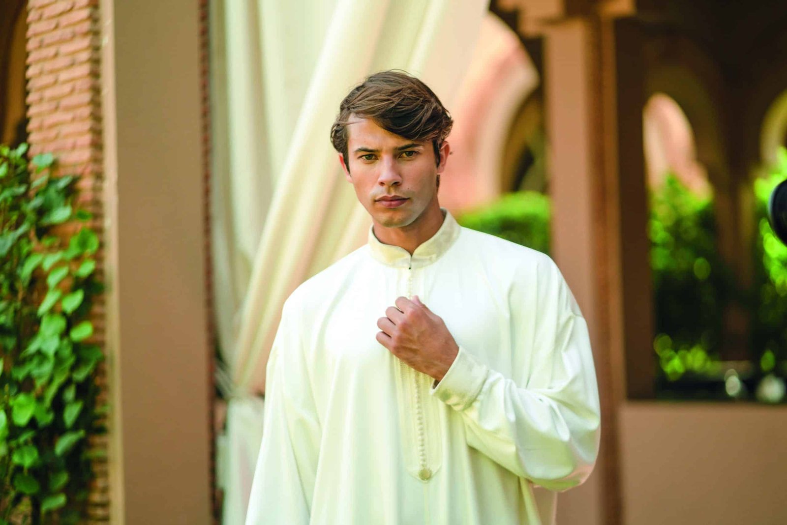 A young man in a white muslim outfit, made in Marrakesh.