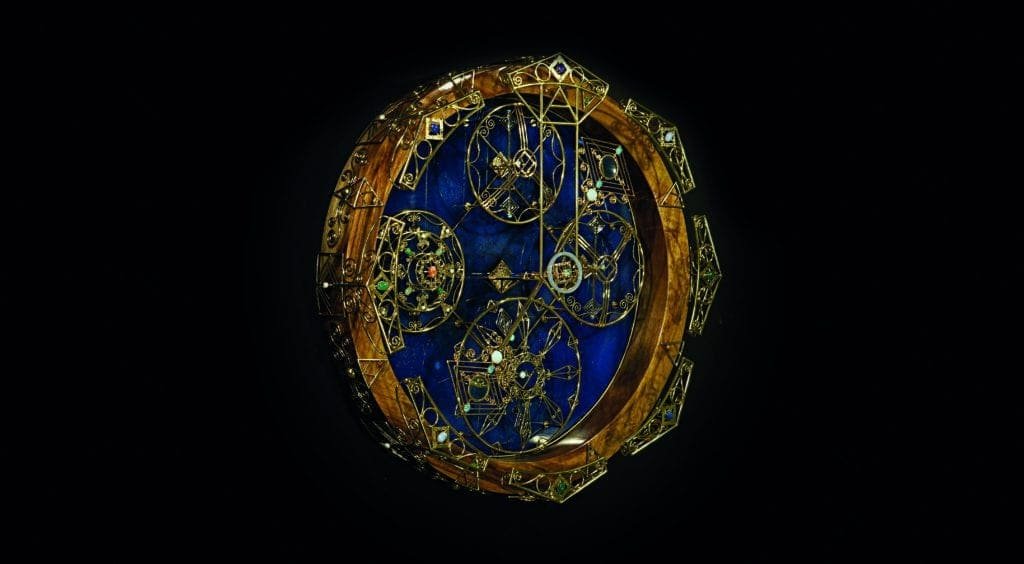 A bejewelled clock on a black background.