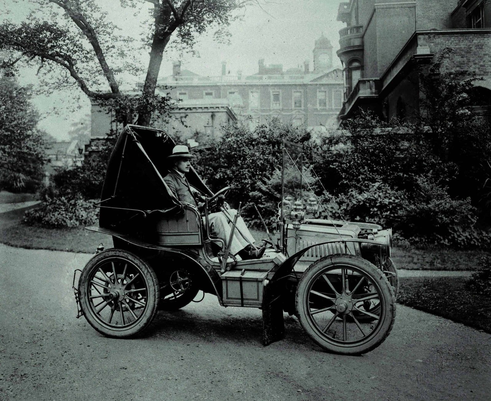 An old black and white photo of a man in a wind-shaped car.