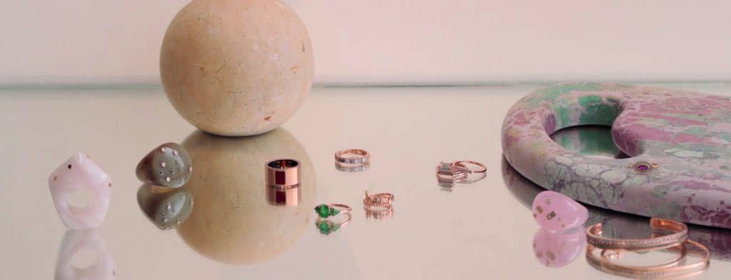 A classic ring and earrings with a twist of a stone are beautifully displayed on a table.