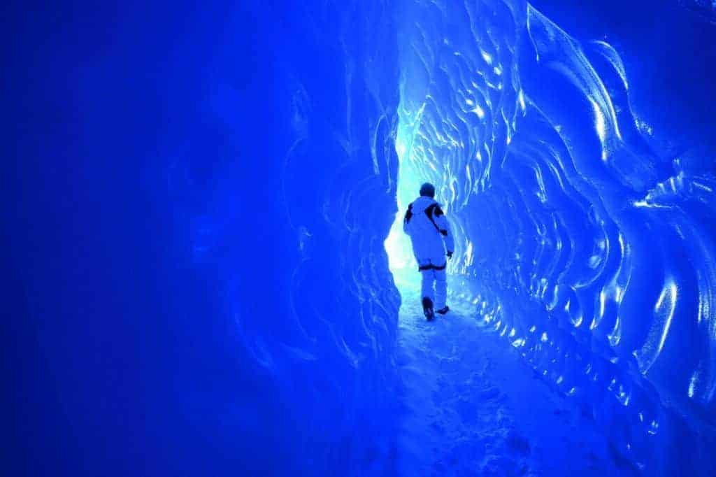 A person embarking on a once-in-a-lifetime trip, walking through an ice cave in Iceland.