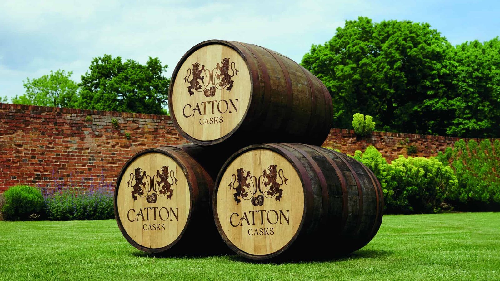 Three wooden barrels stacked on top of each other in front of a brick wall.