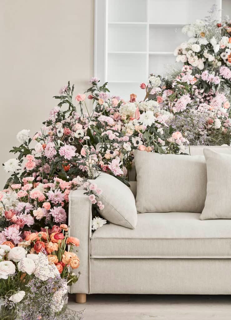 A luxurious couch covered in flowers in a Scandinavian living room.