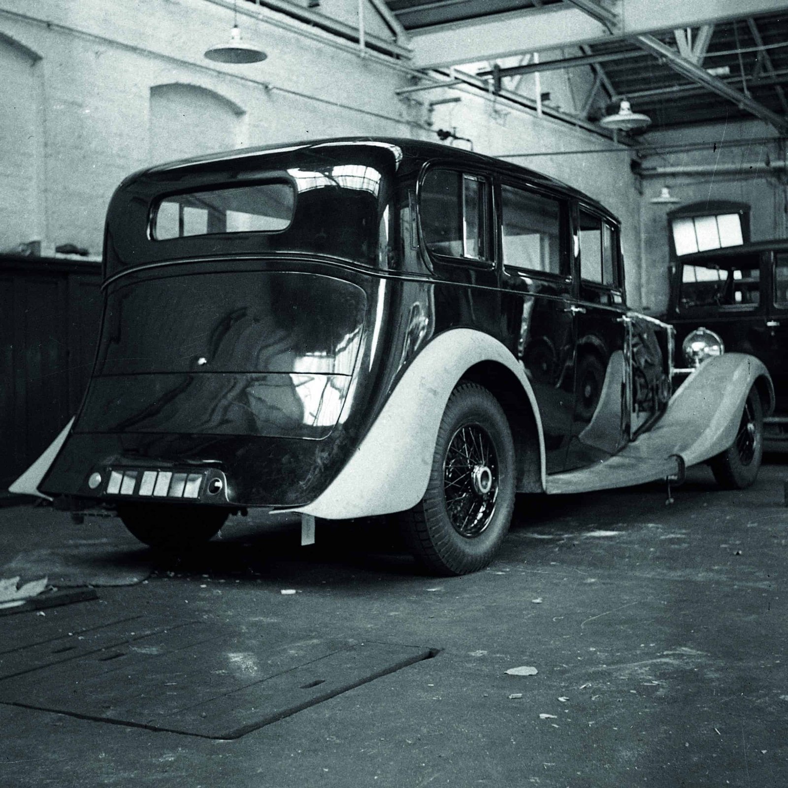 A bold black and white photo showcasing the innovation of an old car in a garage.
