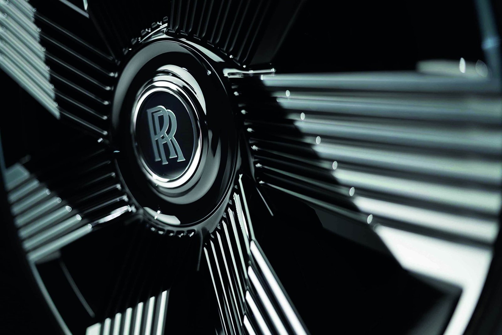 A close up of the wheel of a Rolls Royce, showcasing its grandeur and exquisite craftsmanship.