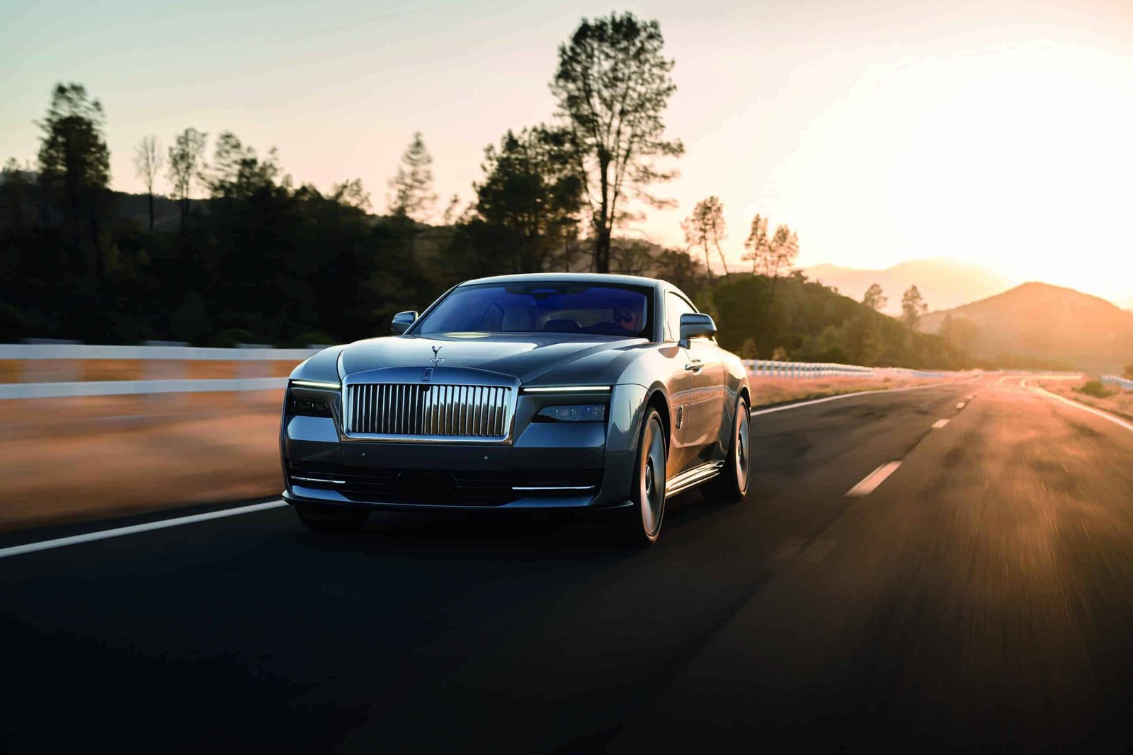 The Spectre model of the Rolls Royce Phantom is driving down the road.