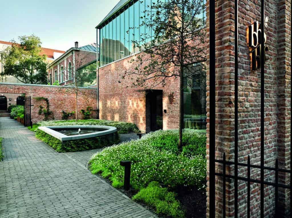 The courtyard of a brick building with a majestic fountain, inviting visitors to behold its beauty.