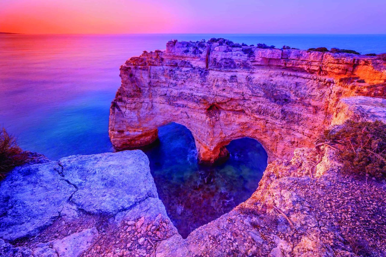 A dreamy heart-shaped cliff turning reality, overlooking the ocean at sunset.